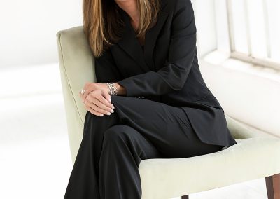 Stephanie Riggs Sitting in Black Suit
